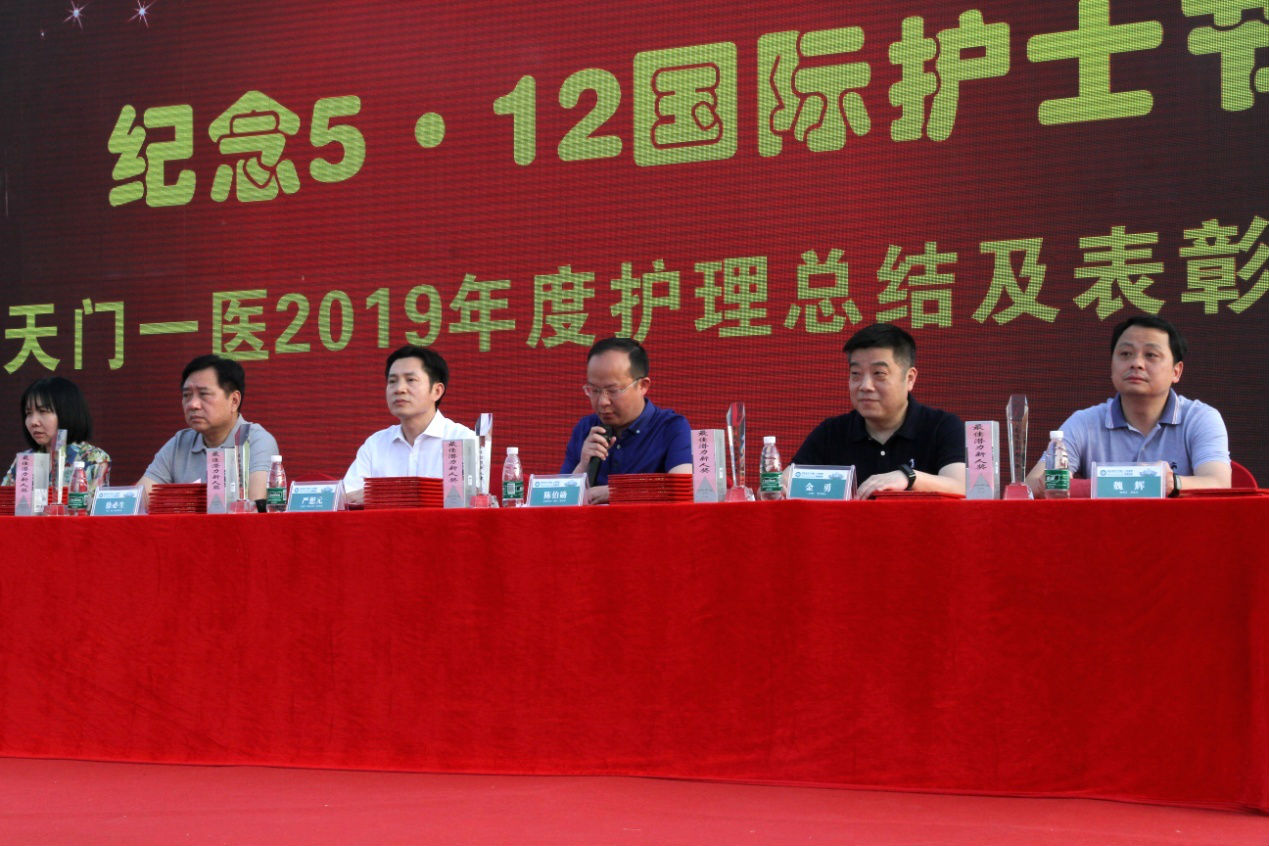 4.天门一医纪委书记陈伯勋(中)宣读《关于表彰2018年度优秀护理团队和先进个人的通报》.png